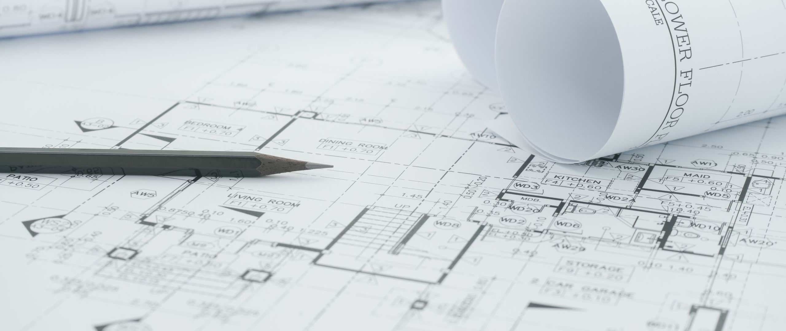 architects workplace - architectural blueprints with measuring tape and black pencil on table.